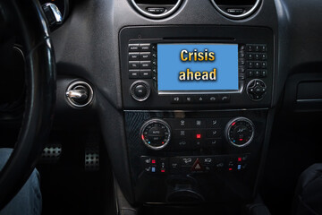 Obraz na płótnie Canvas CRISIS AHEAD is written on the dashboard of the car next to the controls, ignition key and steering wheel
