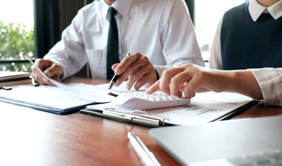 Businessman analyzing investment charts and pressing calculator buttons over documents. Accounting Concept.