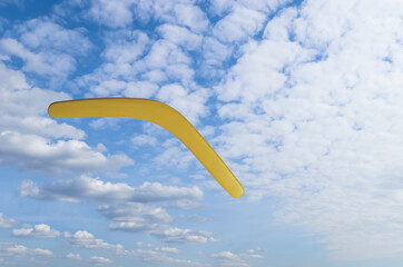 Throwing of boomerang against blue sky. Outdoor activity