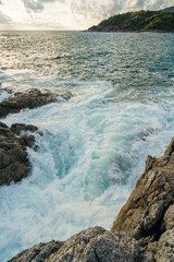 Coral stones and sea waves hitting the rocks on sunset lights