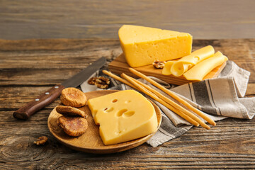 Composition with tasty cheese and snacks on wooden background