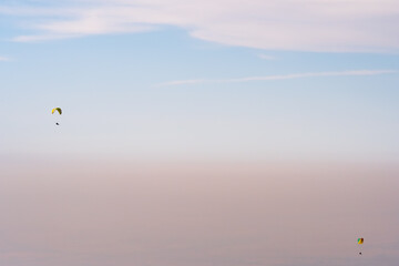 Naklejka na ściany i meble Paraglider silhouette flying on blue sky background. Nature landscape. Concept: adventure, art, travel. Blue sky background. Ushkonyr plateau, Kazakhstan. Travel in Kazakhstan concept.