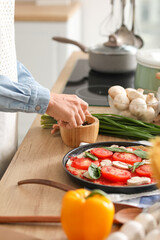 Young woman with mortar and pestle in kitchen