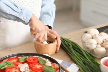 Young woman with mortar and pestle in kitchen