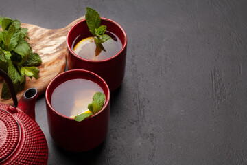 Herbal tea with mint and lemon. Tea cup and teapot