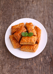 Baklava, traditional Turkish dessert. Crispy baklava on white plate, on a old wooden background. Top view.