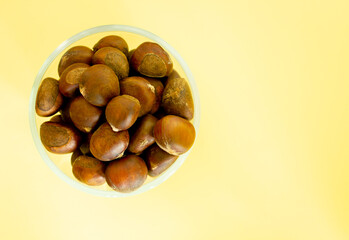 Chestnut kernels in a bowl on a yellow background