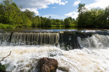 wide small waterfall in summer