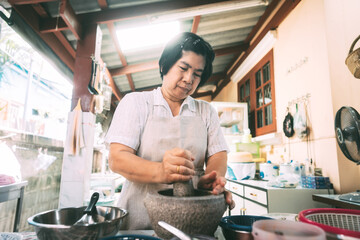 Authentic portrait asian elderly woman cooking local traditional thai style food.