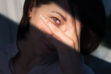 Portrait of woman over dark background with ray of light
