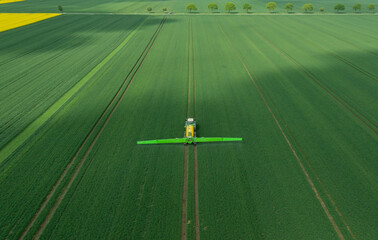 Traktor mit Feldspritze beim Ausbringen von Pflanzenschutzmittel gegen Pestizid © ShDrohnenFly