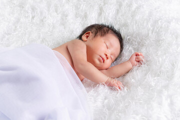 Portrait of a one month old sleeping, newborn baby girl on a white blanket. Concept portrait studio fashion newborn.