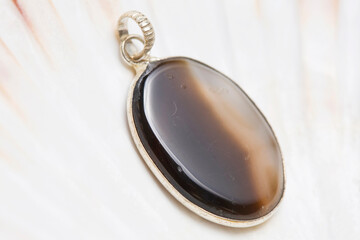 Metal frame mineral stone pendant on white shell background