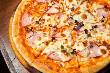 Pizza with bacon and cheese on a dark background. Close-up, selective focus