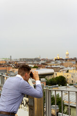 Fototapeta na wymiar a man surveys the city with binoculars