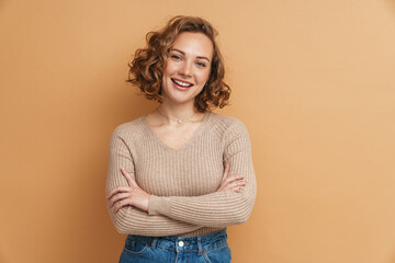Young ginger woman smiling while posing with arms crossed