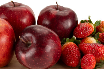 Fresh apples and strawberries on a wooden plate.