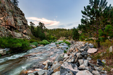 Big Thompson river landscape in the Roosevelt National Forest in Colorado. Stones are visible through the clear water