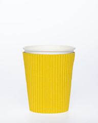 Photo of a disposable yellow  paper cup on a white background. Photo of a coffee cup made of...