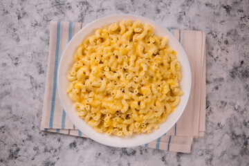 Macaroni and cheese on a white plate on a gray background