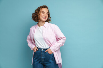 Young ginger woman with wavy hair smiling and looking aside