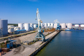 Obraz premium An aerial drone view of the industrial port in the Baltic Sea. There is a ships under load in the harbor. 