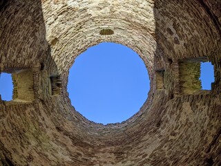 view of the sky through an old and ruined brick building with a round roof