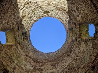 view of the sky through an old and ruined brick building with a round roof