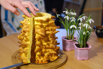 Crop woman cutting traditional Lithuanian cake