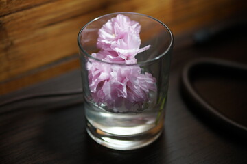 Glass of water on the table. Glass of water on the table. Glass of water flowers. Glass of water. Sakura with glass.