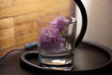 Glass of water on the table. Glass of water flowers. Glass of water. Sakura with glass.