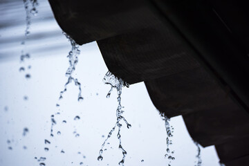 View from under the roof. On a heavy rainy day, rain water fell from the roof of the house.