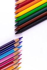 Portrait mode top close up shot of pencil and crayon colors shot on white background.