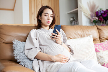 スマートフォンを使ってネットショッピングをする妊婦