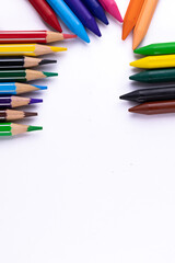 Fototapeta premium Scattered crayons and pencil colors on white background -Art and Education concept.