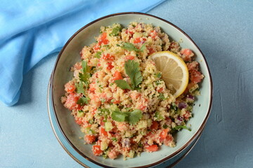 Tabbouleh - a Middle Eastern cuisine vegetarian salad with chopped parsley, tomatoes, mint, onion and bulgur, and seasoned with olive oil, lemon juice.