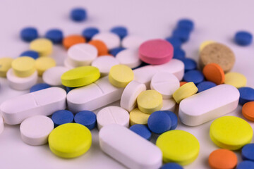 Medical background of multicolored pills on a white background.
Close-up.