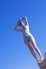young slander happy woman in short summer cropped top and small shorts by the sea