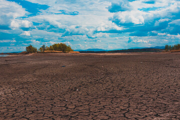 landscape with cracked earth at the bottom of dried up lake