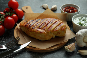 Concept of tasty eating with grilled chicken on black smokey background