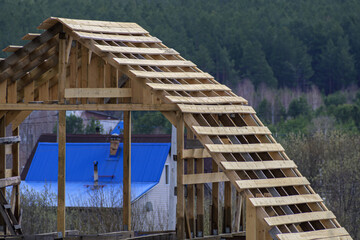 The truss system of a wooden house under construction close-up - obrazy, fototapety, plakaty