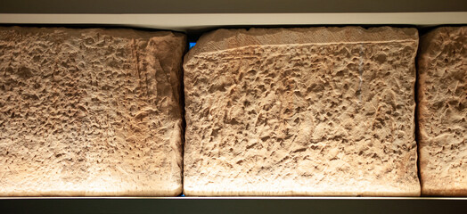 sample of a stone block the processed with a chisel on display, beautifully illuminated with warm...