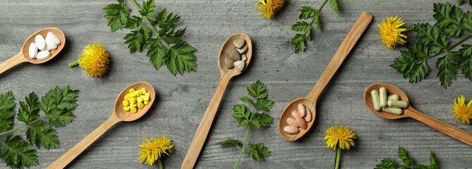 Concept of herbal medicine pills on gray textured background, top view