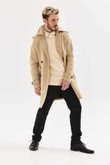 man with trendy hairstyle in beige coat modern style