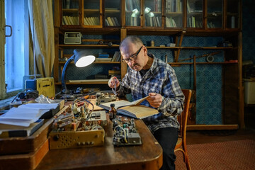 Adult male repairing an old radio receiver
