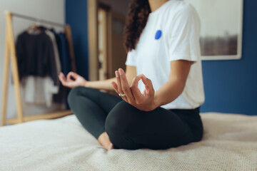 Frau macht Yoga und Dehnübungen zur Entspannung zuhause auf dem Bett