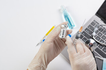 Fototapeta premium Close up a vial of covid-19 vaccine in hand of a scientist or doctor