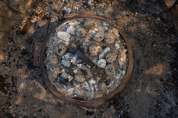 Cooking traditional dalmatian, croatian, bosnian dish called peka. Meat, potatoes and vegetables in pot and covered with hot charcoal and ash. Balkan food.