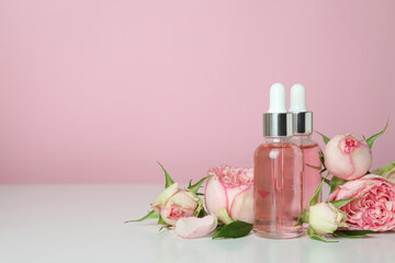 Obraz na płótnie Canvas Skin care concept with essential rose oil on pink background