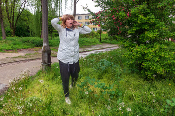 middle-aged woman, pretty, 50 years old, blonde hair, positive, cheerful, outdoors, having a rest, with a very surprised face